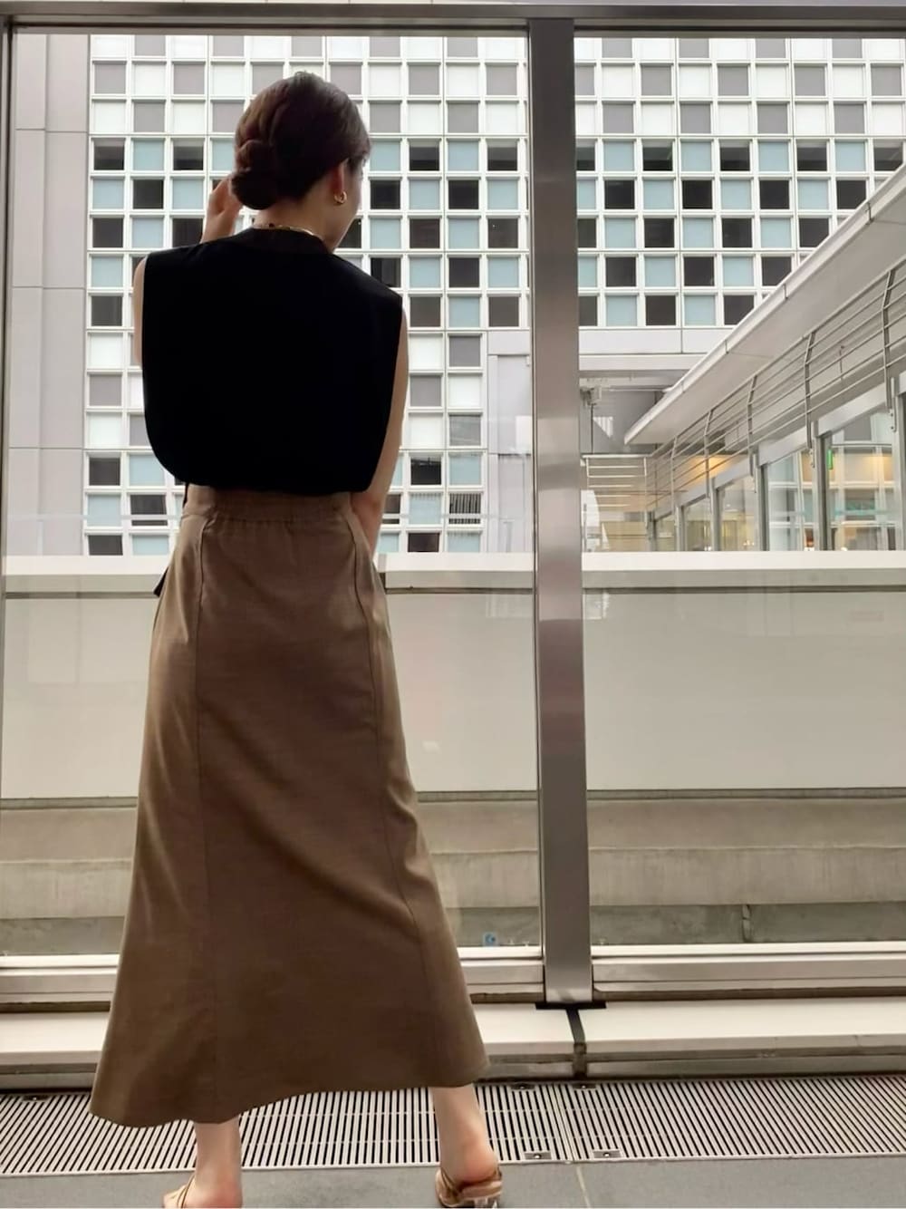 ベージュ系のサンダル、ブラック系のニット/セーター、ブラウン系のスカートを着用したレディースの夏コーディネートの5枚目の写真