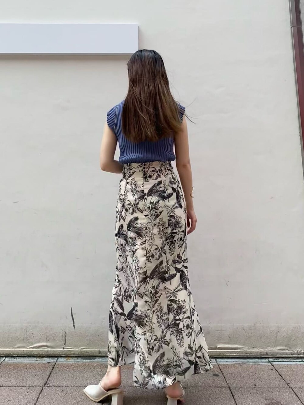 ベージュ系のスカート、ブルー系のニット/セーターを着用したレディースの夏コーディネートの4枚目の写真