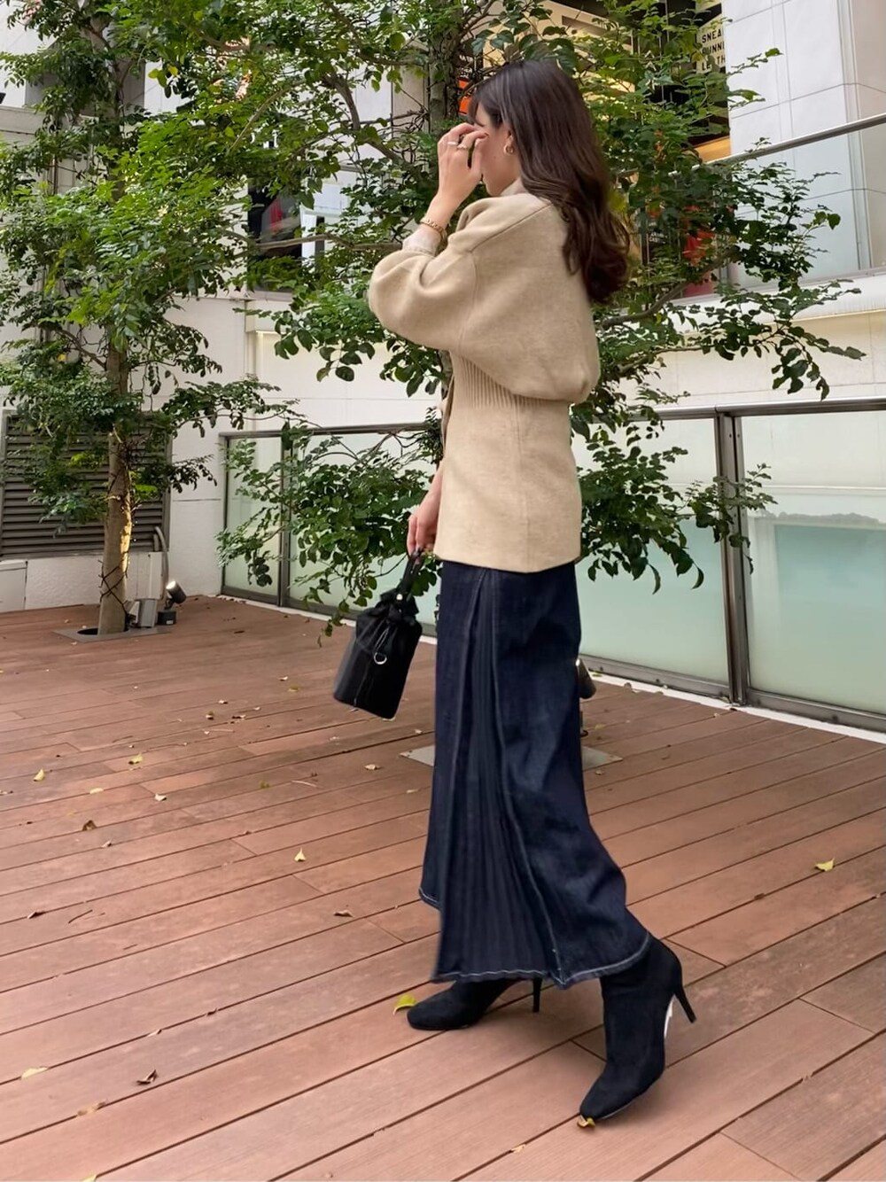 ブラック系のハンドバッグ、ブラック系のブーツ、ブラウン系のシャツ/ブラウスを着用したレディースの秋コーディネートの5枚目の写真