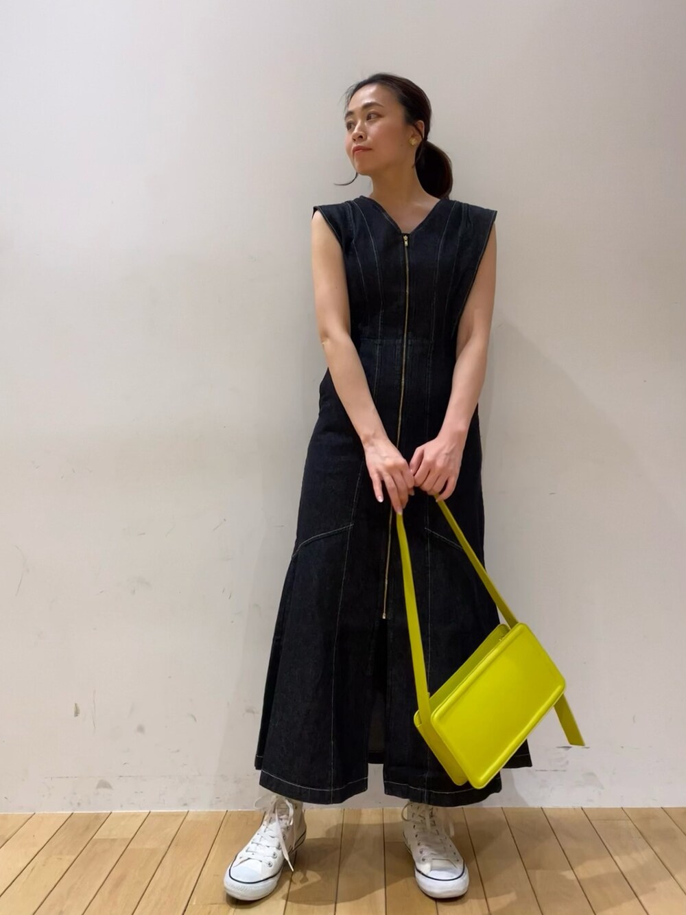 ブラック系のワンピース、グリーン系のショルダーバッグを着用したレディースの春コーディネートの3枚目の写真