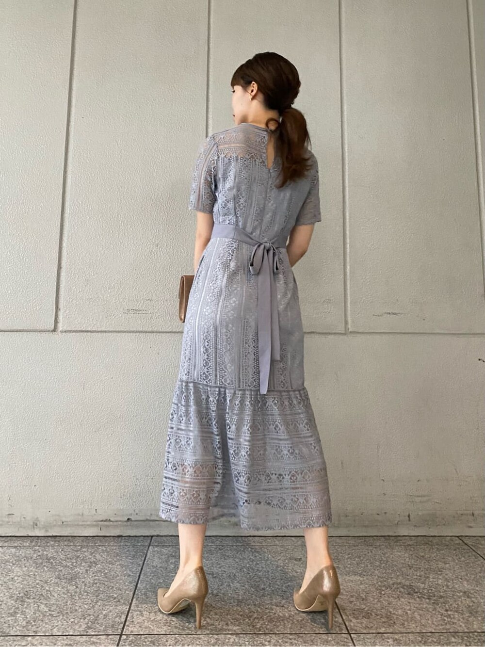 ゴールド系のパンプス、ゴールド系のクラッチバッグ、ブルー系のドレスを着用したレディースの夏コーディネートの4枚目の写真