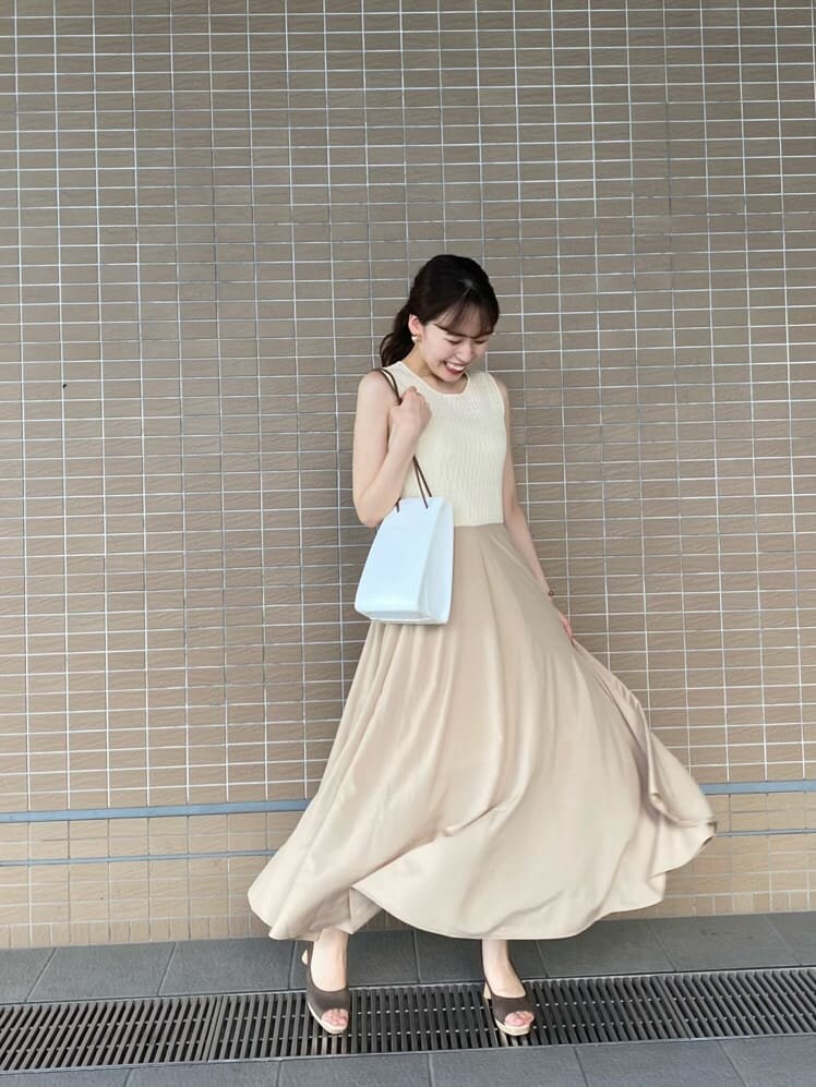 ブラウン系のパンプス、ホワイト系のハンドバッグ、ホワイト系のワンピースを着用したレディースの夏コーディネートの2枚目の写真