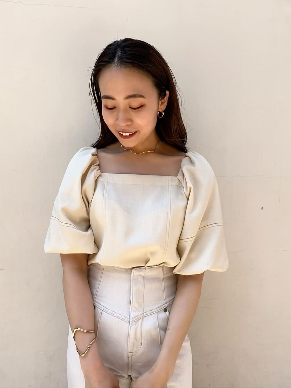 ホワイト系のデニムパンツ、ホワイト系のショルダーバッグ、ベージュ系のサンダルを着用したレディースの夏コーディネートの3枚目の写真