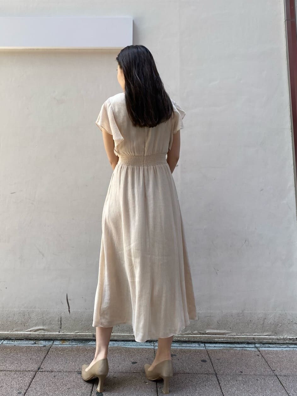 ベージュ系のパンプス、ホワイト系のワンピースを着用したレディースの夏コーディネートの2枚目の写真