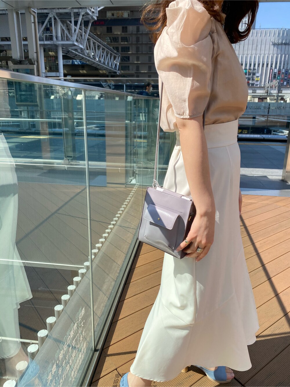 ベージュ系のシャツ/ブラウス、ブルー系のパンプス、パープル系のハンドバッグを着用したレディースの春コーディネートの4枚目の写真