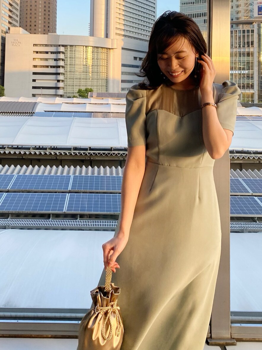 ブラック系のその他シューズ、グリーン系のドレス、ゴールド系のハンドバッグを着用したレディースの春コーディネートの2枚目の写真