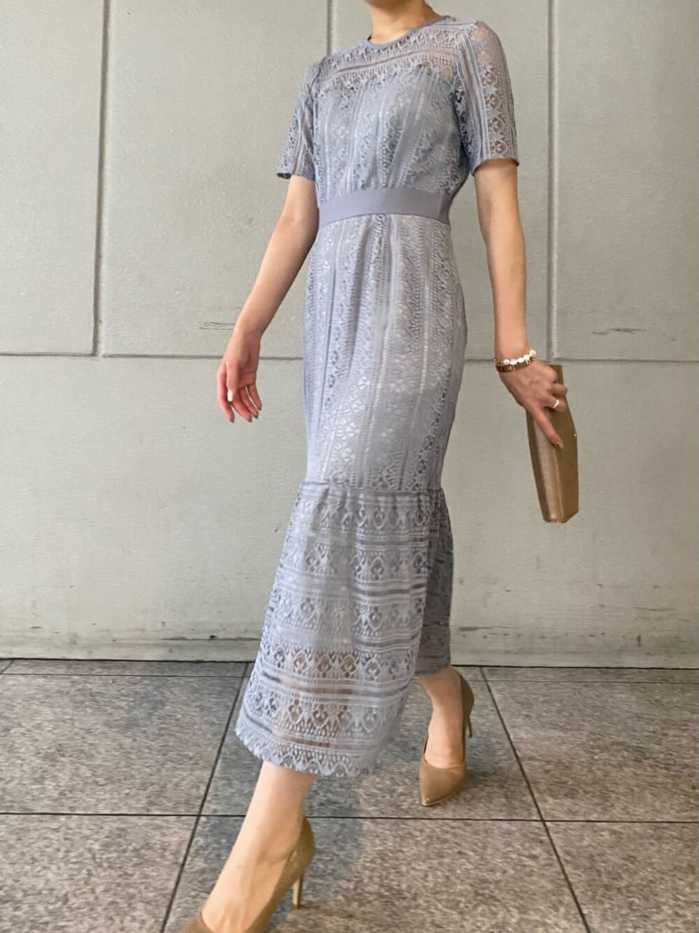 ゴールド系のパンプス、ゴールド系のクラッチバッグ、ブルー系のドレスを着用したレディースの夏コーディネートの2枚目の写真