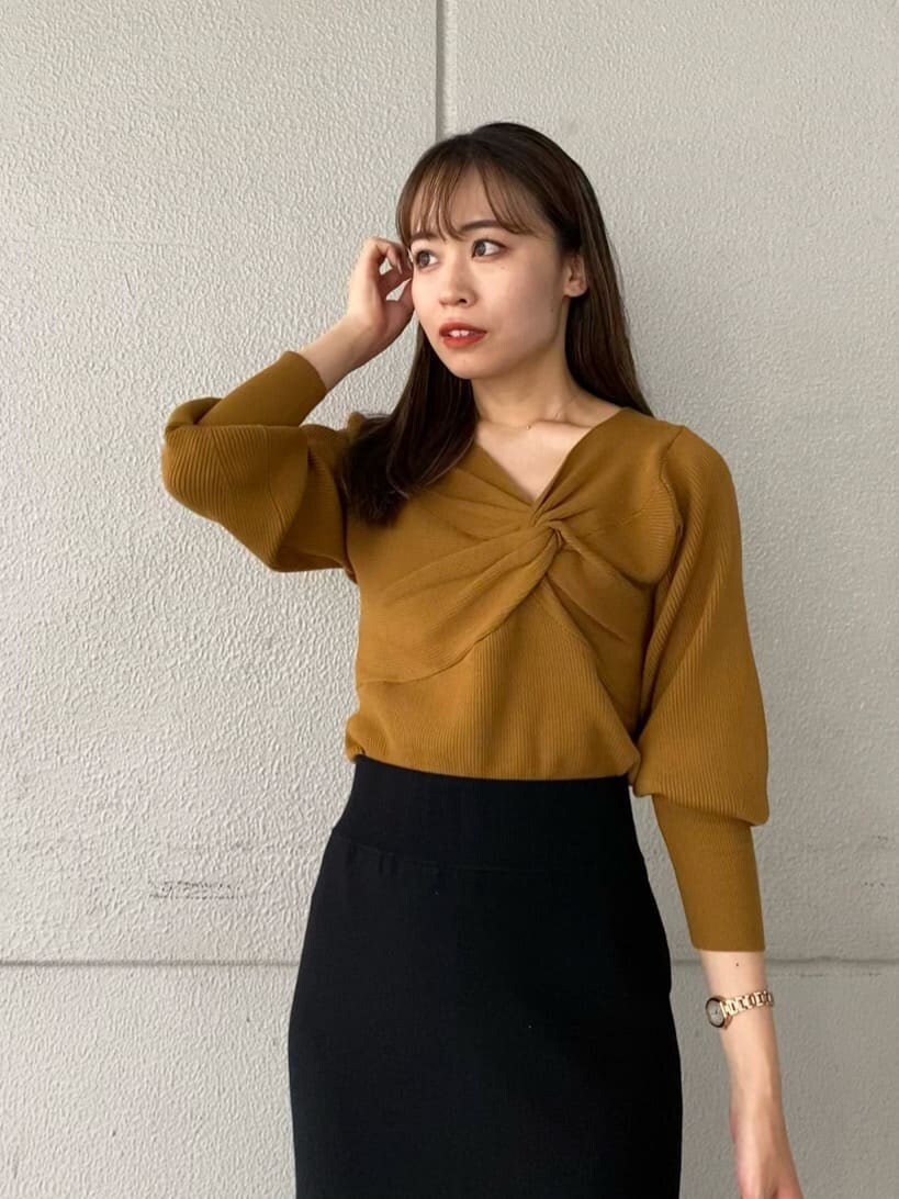 ブラック系のその他シューズ、ブラック系のスカート、イエロー系のニット/セーターを着用したレディースの秋コーディネートの2枚目の写真