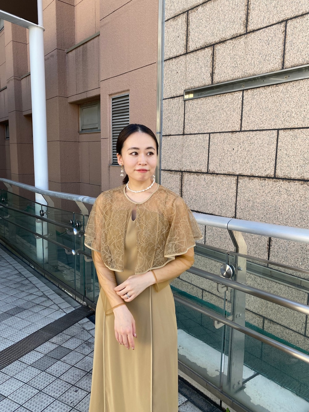 ベージュ系のドレス、ベージュ系のテーラードジャケット、ベージュ系のハンドバッグを着用したレディースの秋コーディネートの4枚目の写真