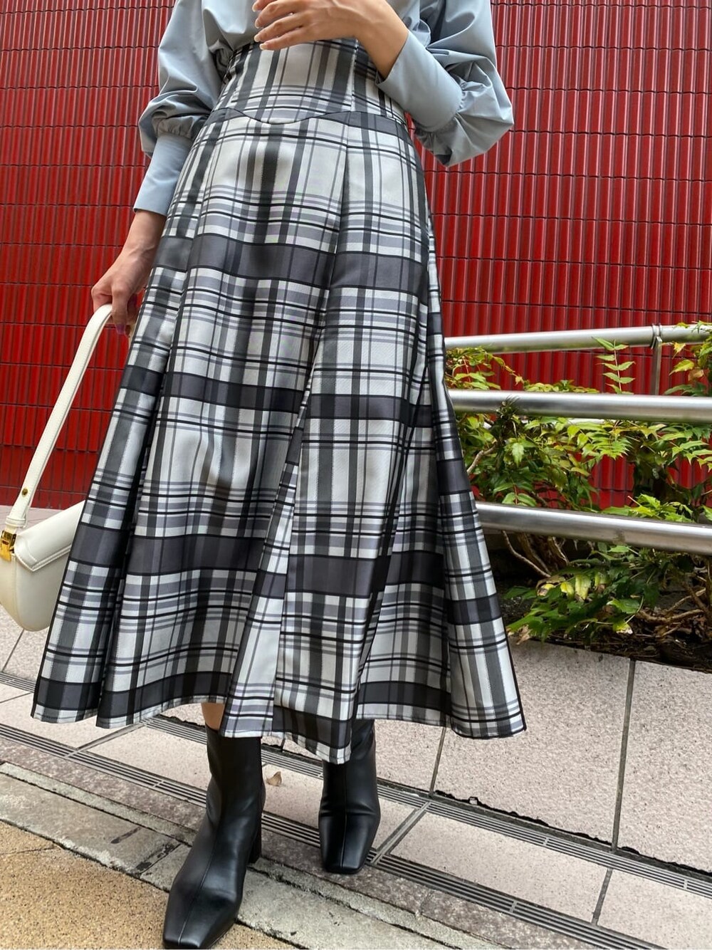 ホワイト系のショルダーバッグ、ブルー系のシャツ/ブラウス、ブラック系のブーツを着用したレディースの夏コーディネートの2枚目の写真