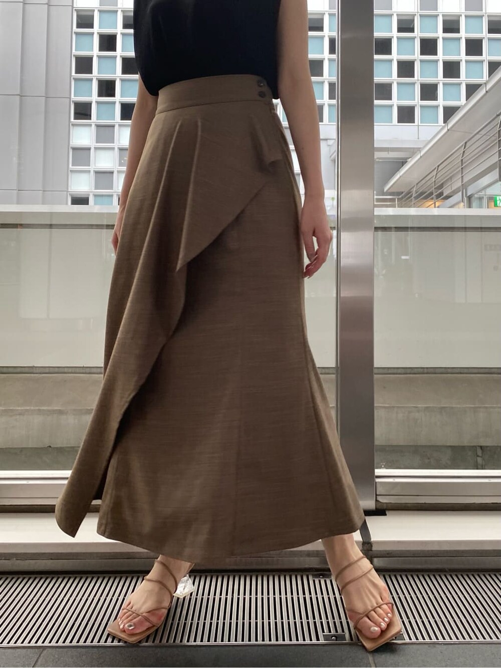 ベージュ系のサンダル、ブラック系のニット/セーター、ブラウン系のスカートを着用したレディースの夏コーディネートの4枚目の写真