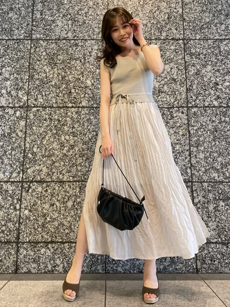ブラウン系のパンプス、ブラック系のハンドバッグ、グレー系のワンピースを着用したレディースの夏コーディネートの2枚目の写真