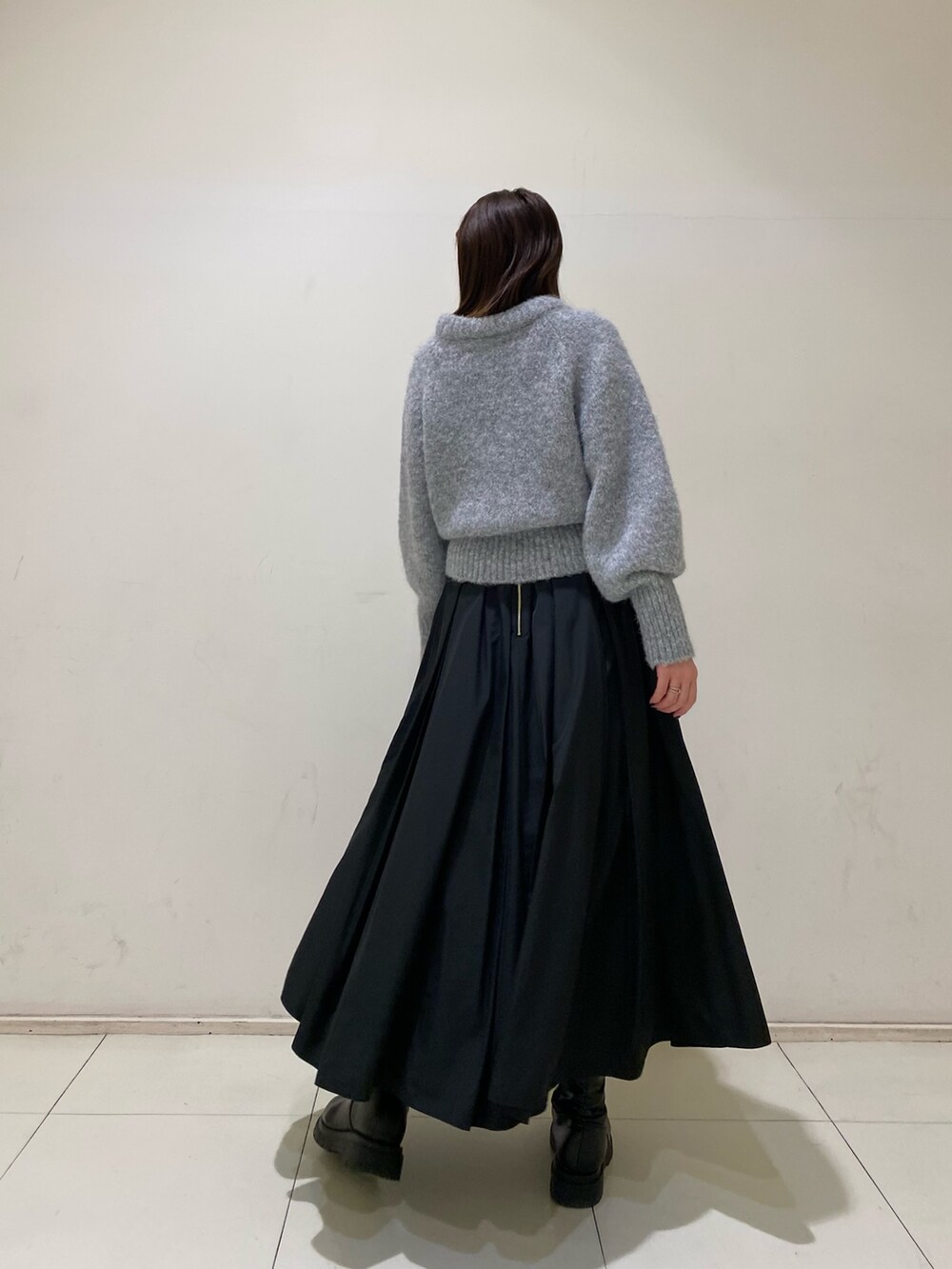 グレー系のニット/セーター、ブラック系のスカートを着用したレディースの冬コーディネートの3枚目の写真