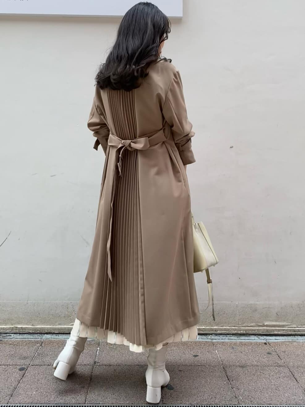 ベージュ系のトレンチコート、ホワイト系のワンピース、ホワイト系のハンドバッグを着用したレディースの春コーディネートの5枚目の写真