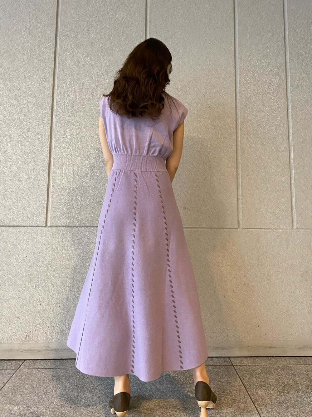 ブラウン系のパンプス、ブラック系のハンドバッグ、パープル系のワンピースを着用したレディースの夏コーディネートの6枚目の写真