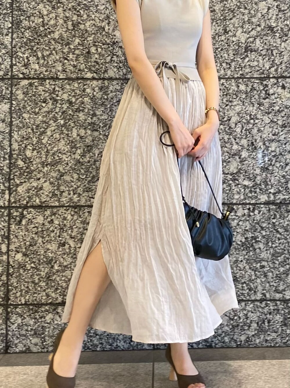 ブラウン系のパンプス、ブラック系のハンドバッグ、グレー系のワンピースを着用したレディースの夏コーディネートの3枚目の写真