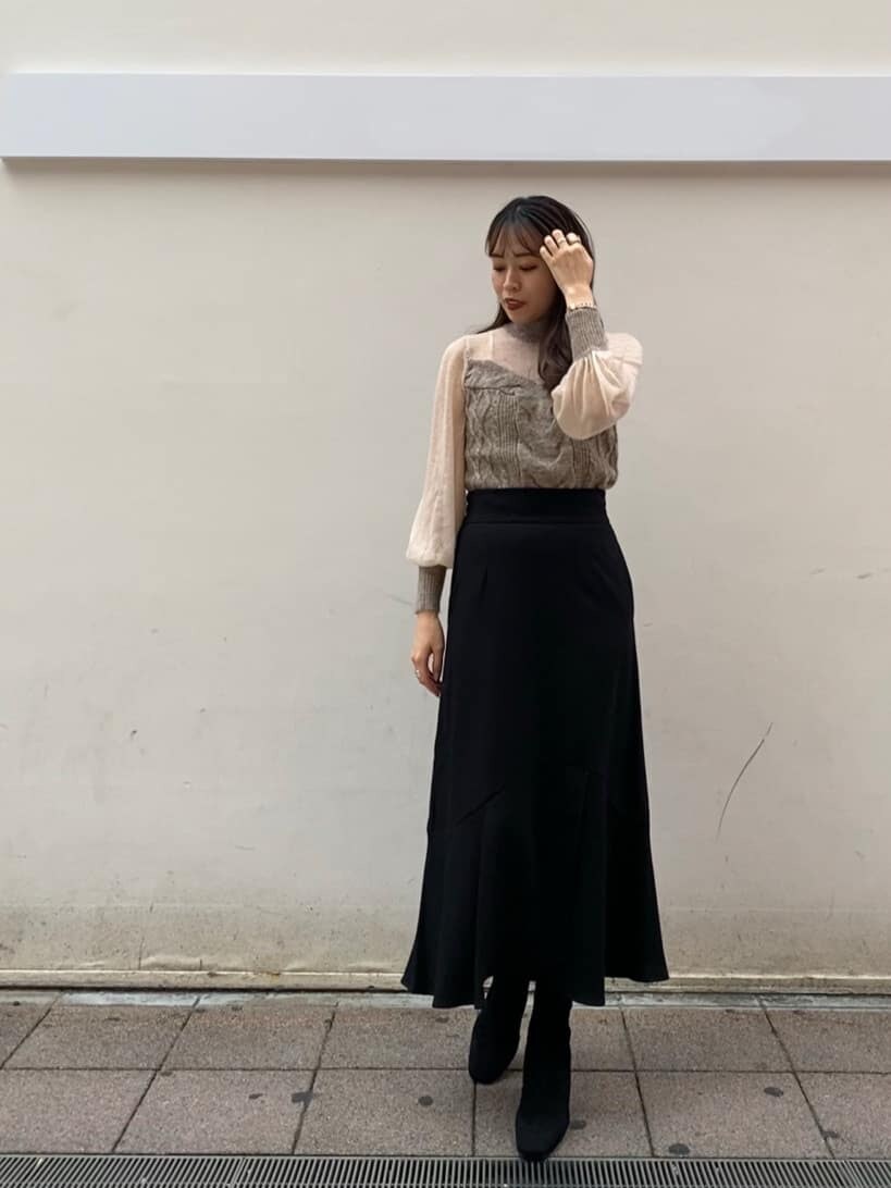 ブラック系のブーツ、ホワイト系のノーカラーコート、ブラック系のスカートを着用したレディースの秋コーディネートの3枚目の写真