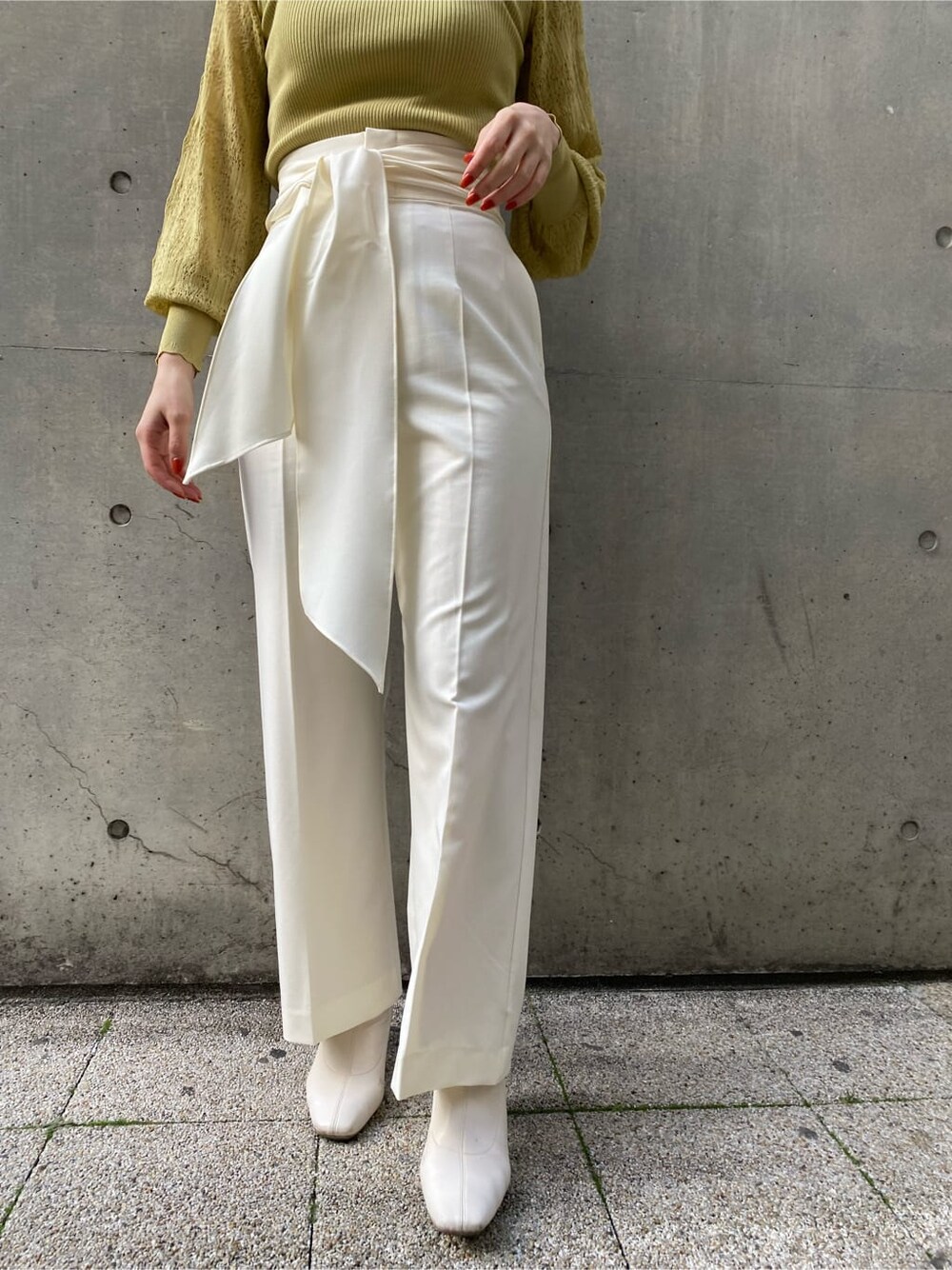 ホワイト系のその他パンツ、ベージュ系のノーカラーコート、イエロー系のニット/セーターを着用したレディースの冬コーディネートの6枚目の写真