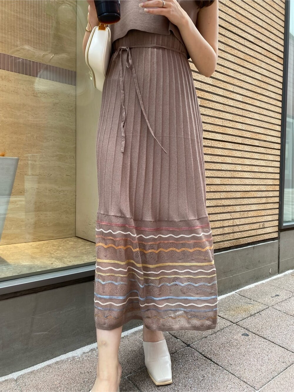 ブラウン系のワンピース、ホワイト系のショルダーバッグを着用したレディースの夏コーディネートの3枚目の写真