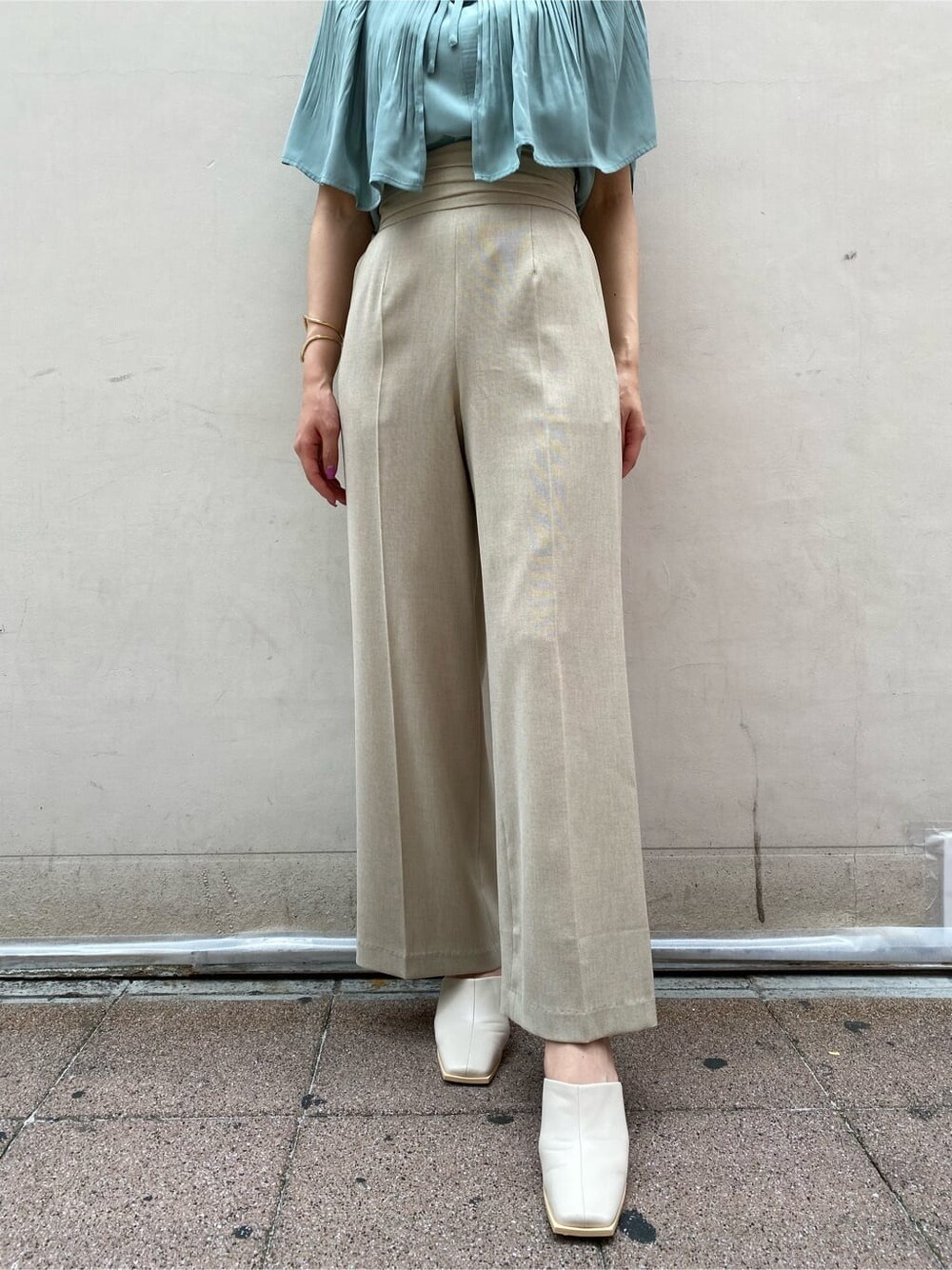 ベージュ系のその他パンツ、グリーン系のシャツ/ブラウス、ホワイト系のサンダルを着用したレディースの夏コーディネートの2枚目の写真