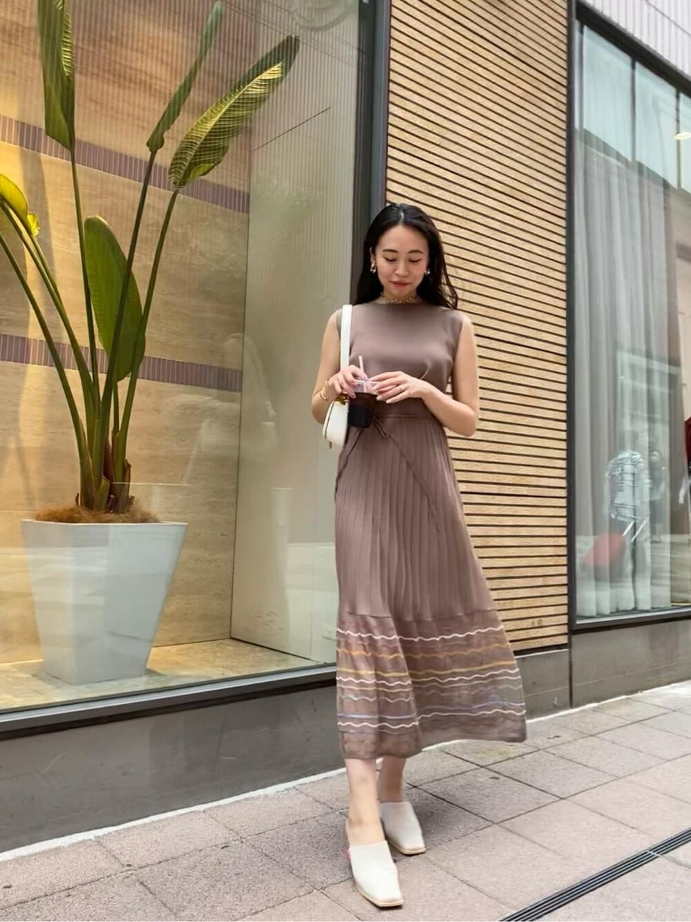 ブラウン系のワンピース、ホワイト系のショルダーバッグを着用したレディースの夏コーディネートの2枚目の写真