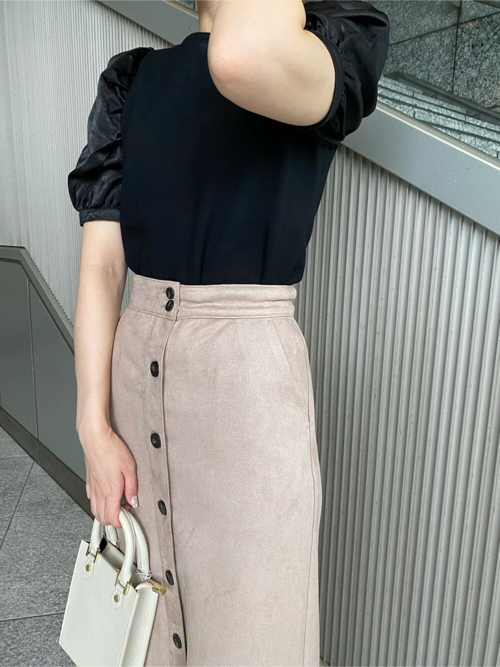 ブラック系のニット/セーター、ベージュ系のスカート、ブラック系のその他シューズを着用したレディースの夏コーディネートの5枚目の写真