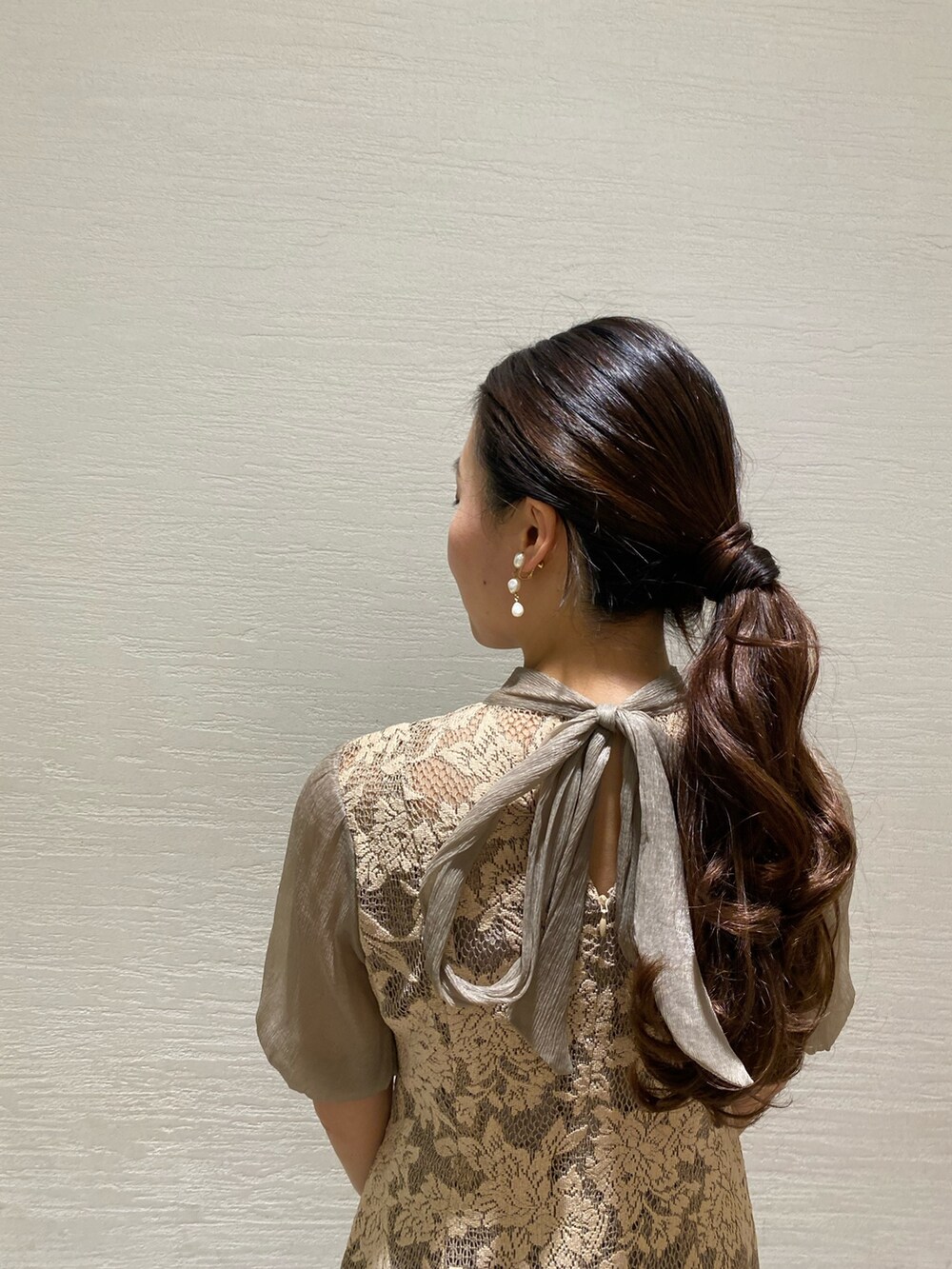 ベージュ系のドレス、ゴールド系のクラッチバッグ、ゴールド系のパンプスを着用したレディースの秋コーディネートの4枚目の写真