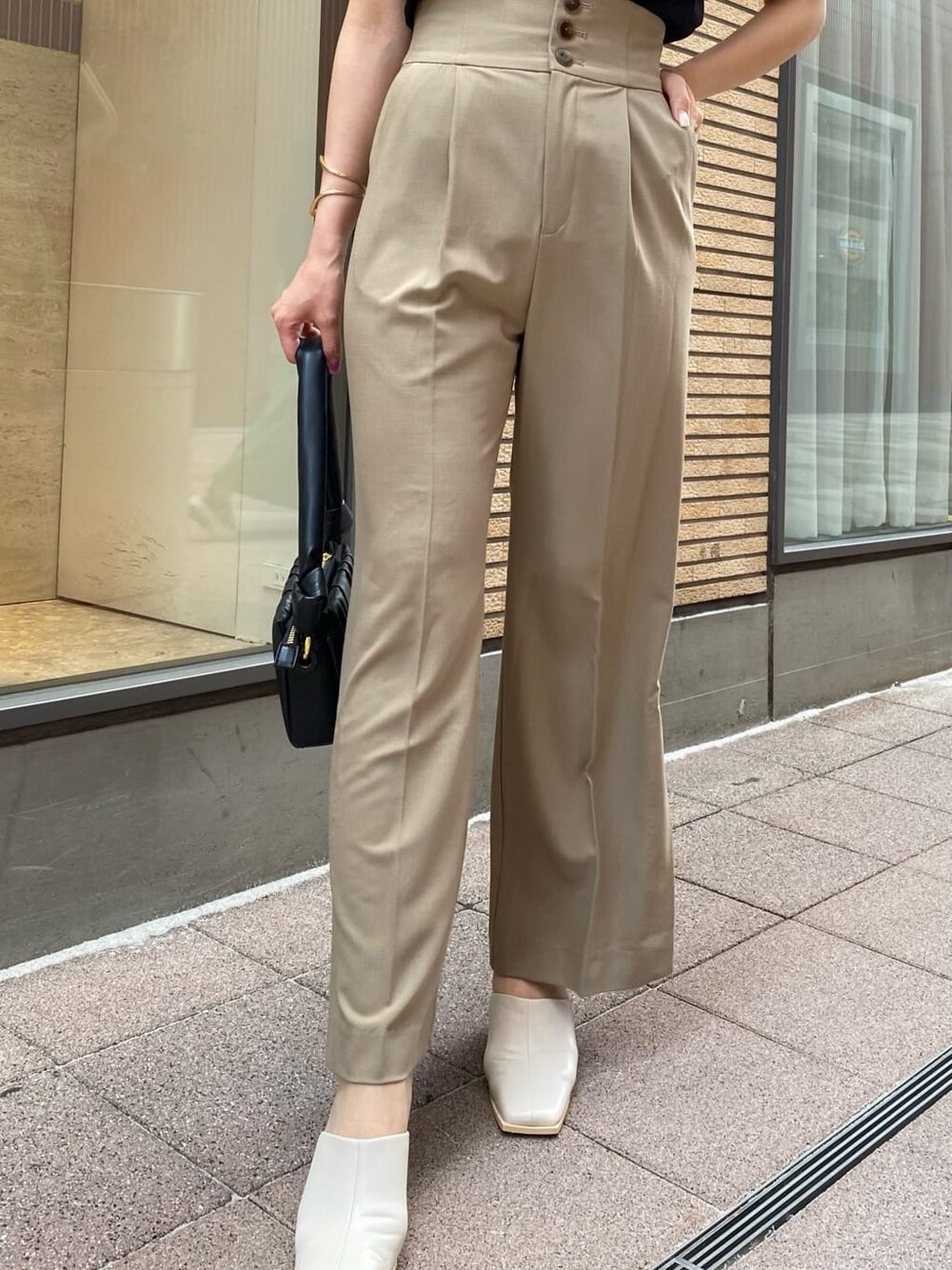 ベージュ系のその他パンツ、ブラック系のハンドバッグ、ブラック系のシャツ/ブラウスを着用したレディースの夏コーディネートの2枚目の写真