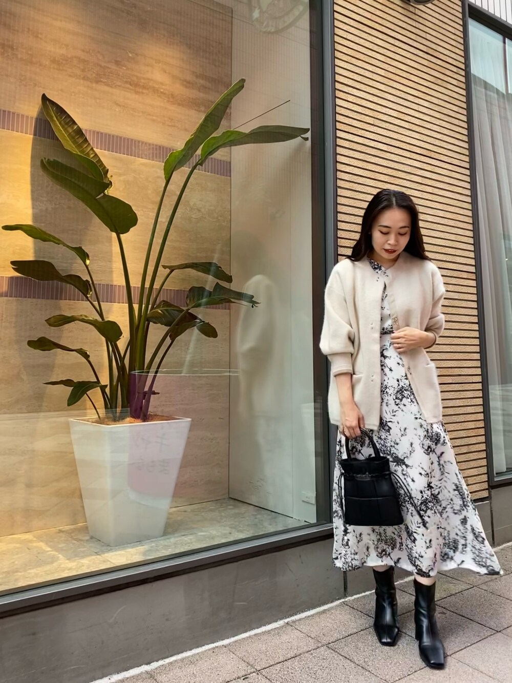 ホワイト系のカーディガン/ボレロ、グレー系のワンピースを着用したレディースの秋コーディネートの3枚目の写真