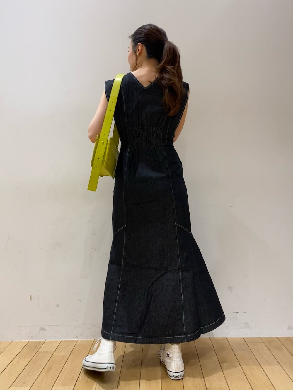 ブラック系のワンピース、グリーン系のショルダーバッグを着用したレディースの春コーディネートの4枚目の写真