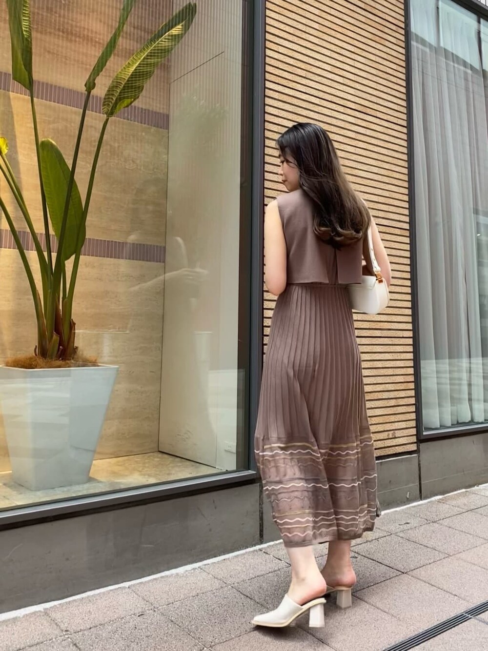 ブラウン系のワンピース、ホワイト系のショルダーバッグを着用したレディースの夏コーディネートの4枚目の写真