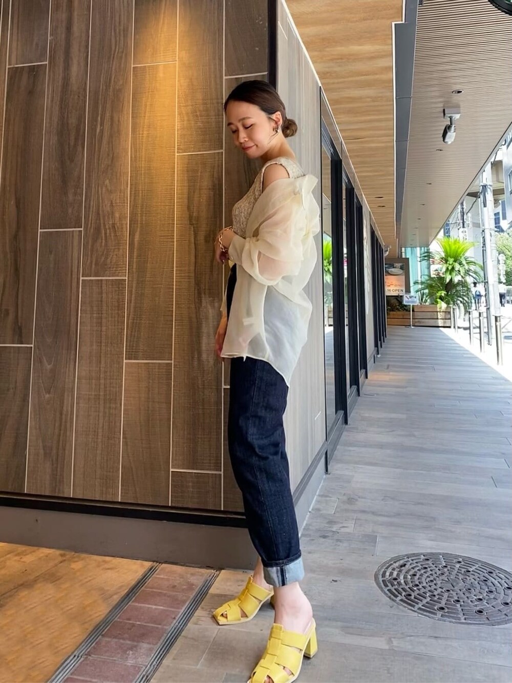 ホワイト系のシャツ/ブラウス、ブルー系のデニムパンツ、イエロー系のサンダルを着用したレディースの夏コーディネートの3枚目の写真