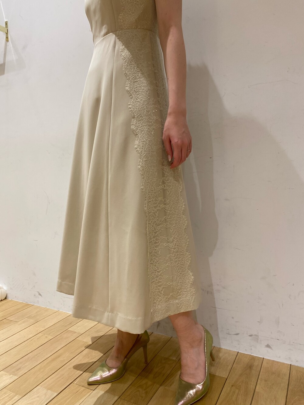 ベージュ系のドレス、ゴールド系のクラッチバッグ、ゴールド系のパンプスを着用したレディースの春コーディネートの4枚目の写真