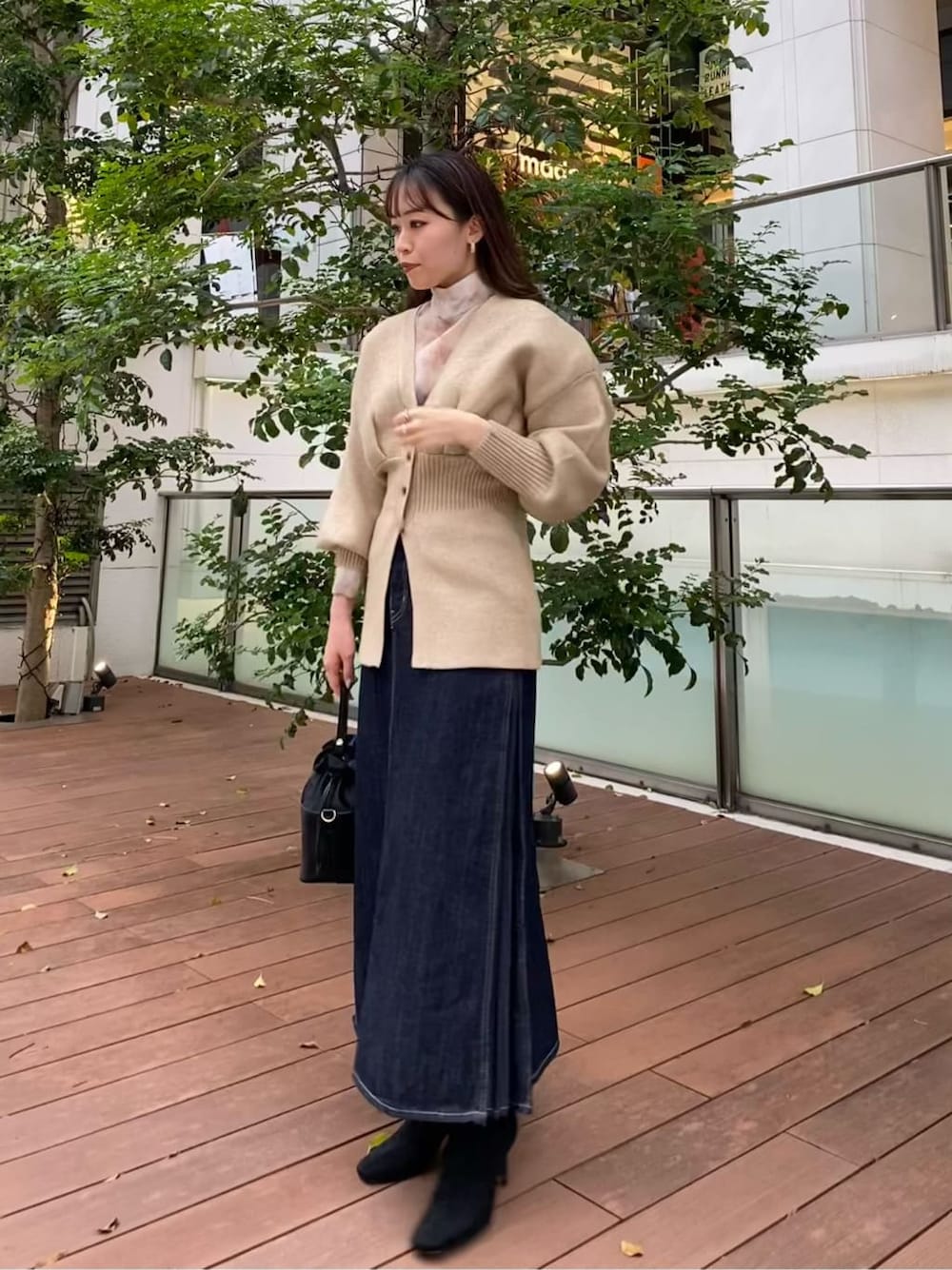 ブラック系のハンドバッグ、ブラック系のブーツ、ブラウン系のシャツ/ブラウスを着用したレディースの秋コーディネートの2枚目の写真