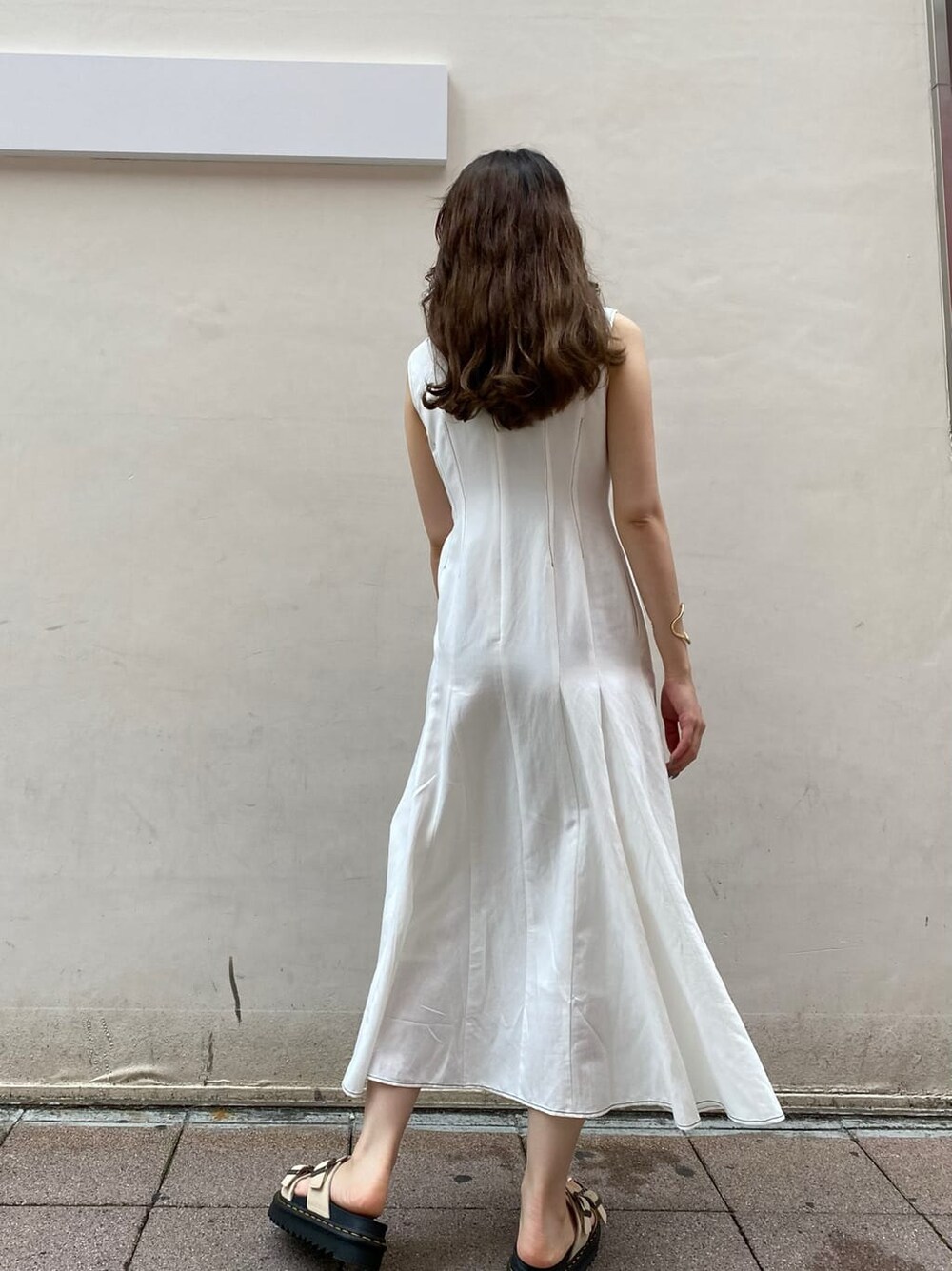 ベージュ系のサンダル、ホワイト系のワンピースを着用したレディースの夏コーディネートの2枚目の写真