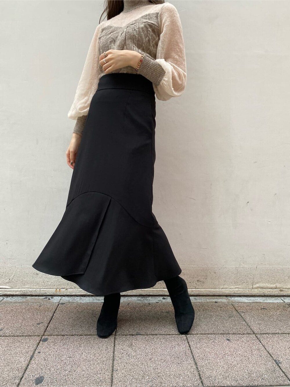 ブラック系のブーツ、ホワイト系のノーカラーコート、ブラック系のスカートを着用したレディースの秋コーディネートの4枚目の写真