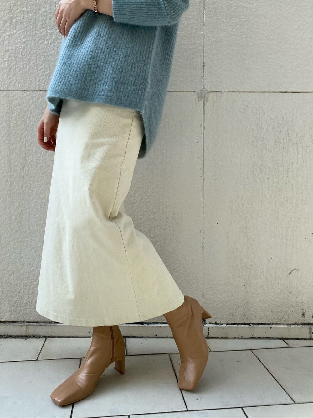 ベージュ系のその他シューズ、ホワイト系のスカート、グリーン系のニット/セーターを着用したレディースの秋コーディネートの4枚目の写真