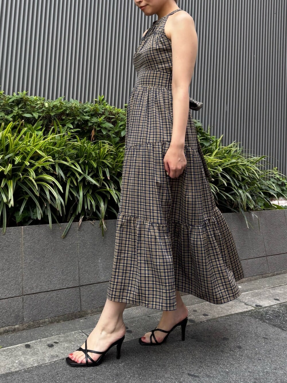イエロー系のワンピース、ブラック系のサンダル、ホワイト系のカーディガン/ボレロを着用したレディースの夏コーディネートの3枚目の写真