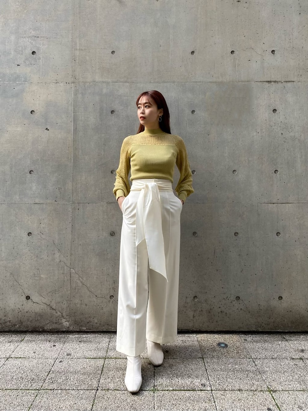 ホワイト系のその他パンツ、ベージュ系のノーカラーコート、イエロー系のニット/セーターを着用したレディースの冬コーディネートの3枚目の写真