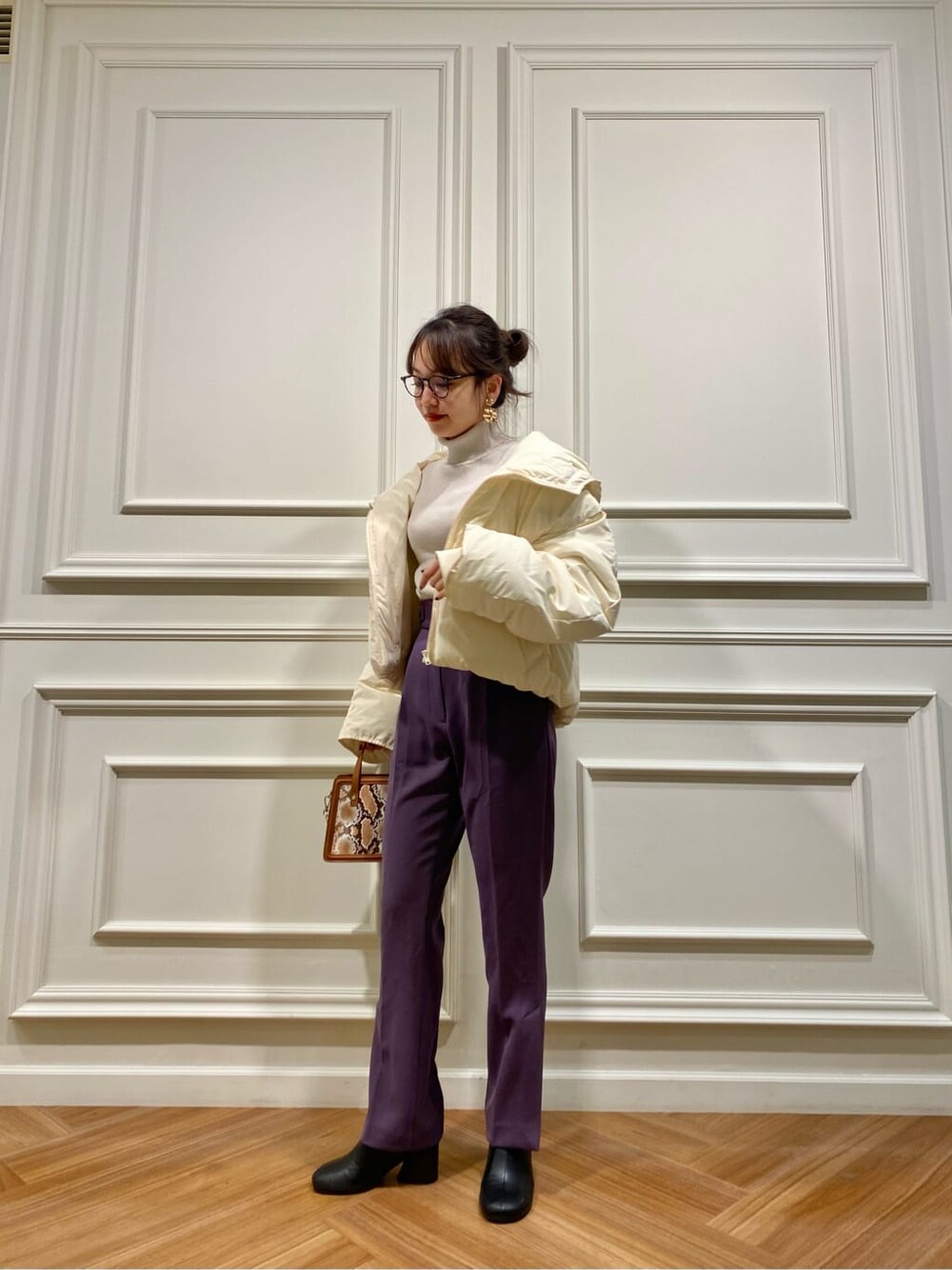 ホワイト系のダウンジャケット/コート、ブラック系のブーツ、パープル系のその他パンツを着用したレディースの秋コーディネートの3枚目の写真