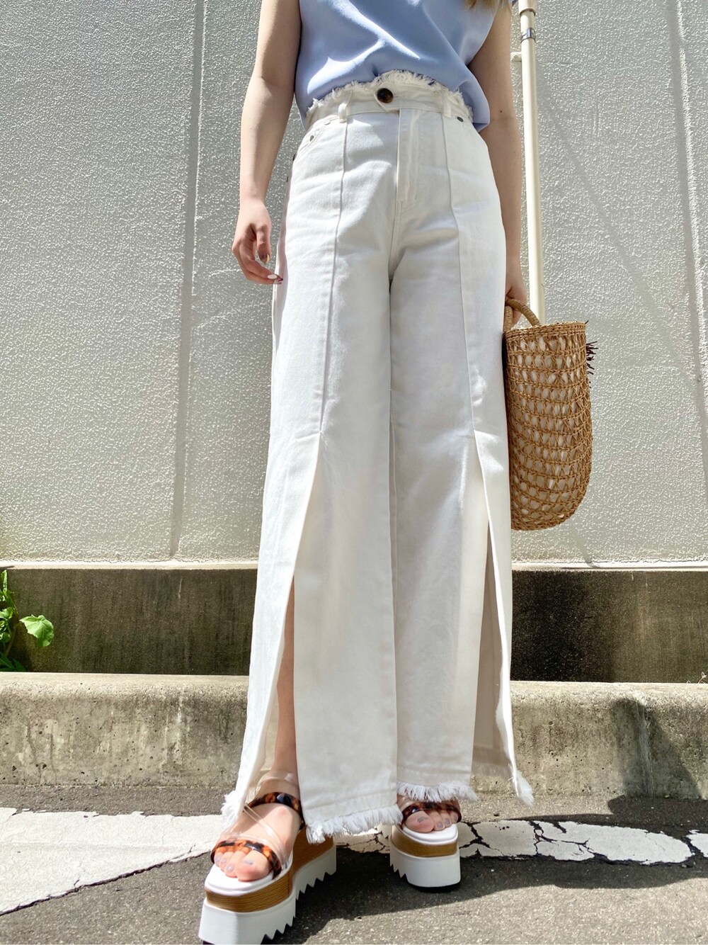 ベージュ系のかごバッグ、ブルー系のTシャツ/カットソー、ホワイト系のその他パンツを着用したレディースの春コーディネートの4枚目の写真
