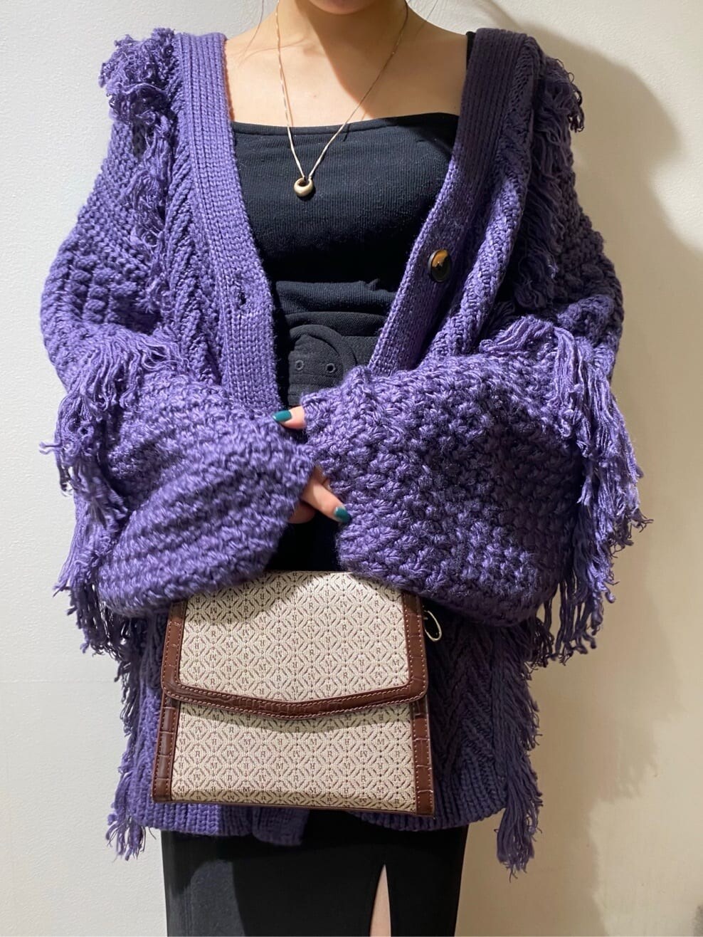 ブラック系のスカート、ブラック系のブーツ、パープル系のカーディガン/ボレロを着用したレディースの秋コーディネートの5枚目の写真