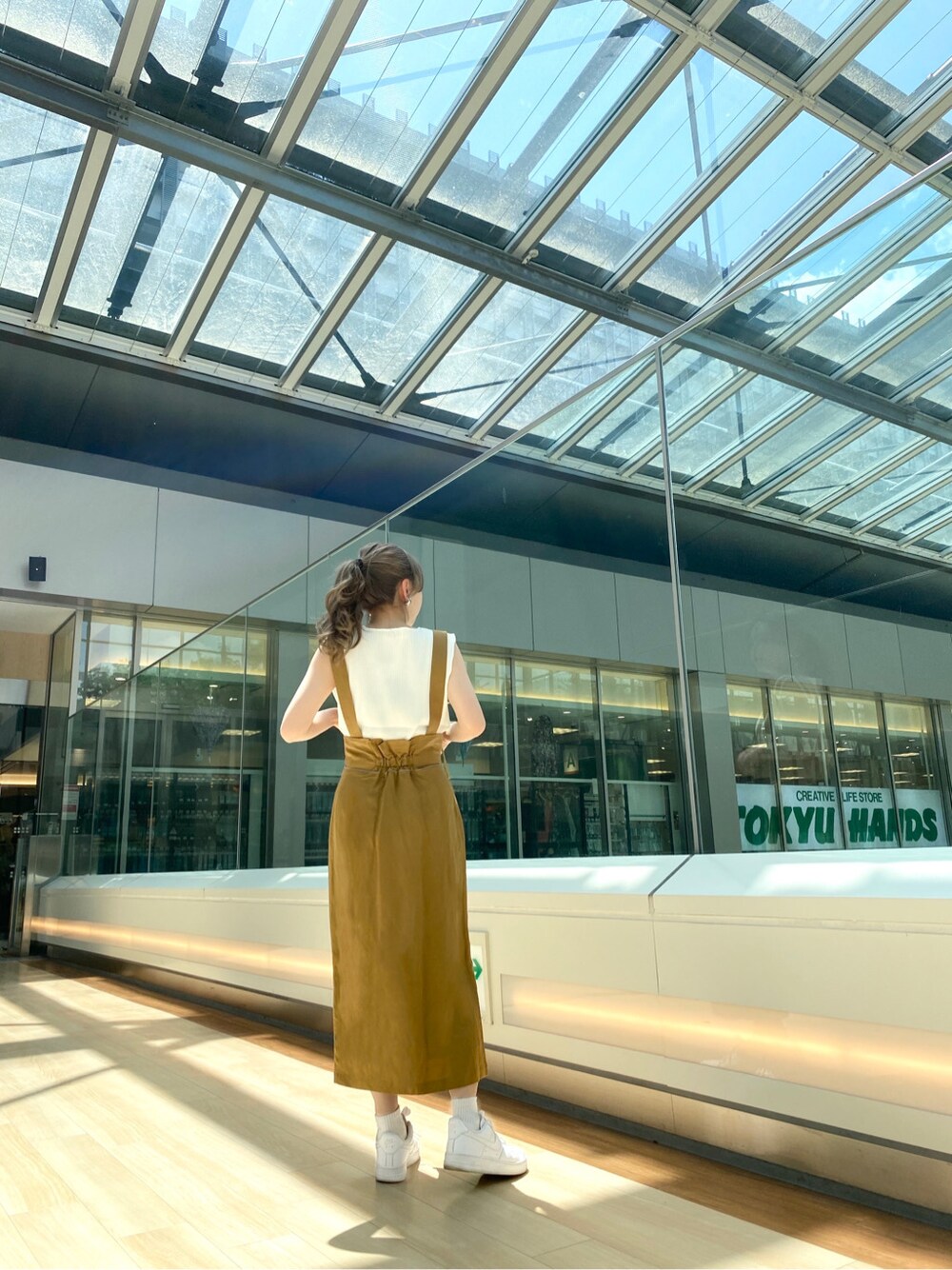 ホワイト系のニット/セーター、イエロー系のワンピースを着用したレディースの春コーディネートの3枚目の写真