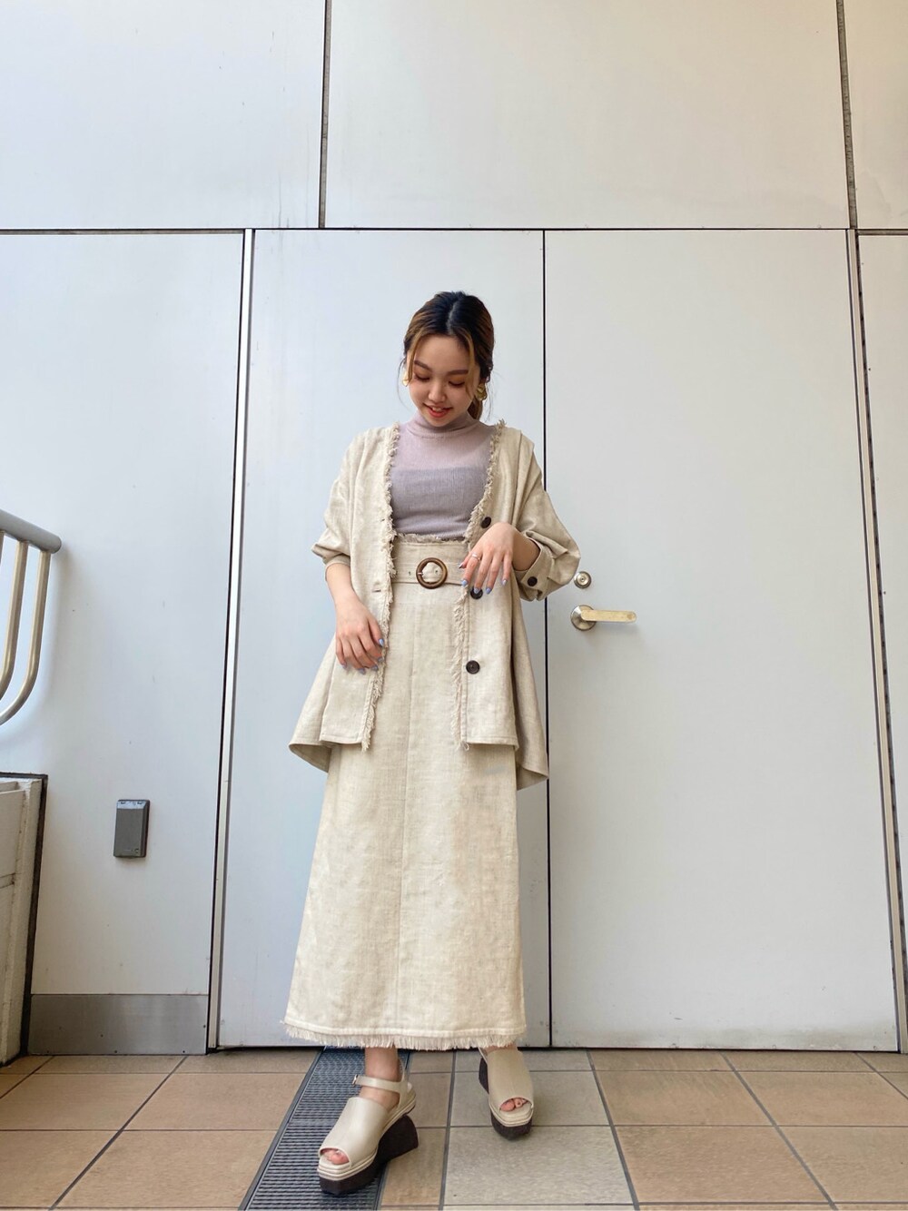 ホワイト系のスカート、ホワイト系のサンダル、ホワイト系のテーラードジャケットを着用したレディースの春コーディネートの4枚目の写真