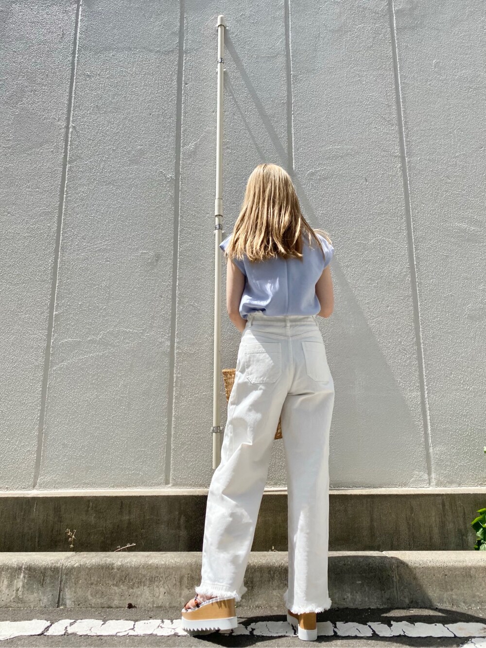 ベージュ系のかごバッグ、ブルー系のTシャツ/カットソー、ホワイト系のその他パンツを着用したレディースの春コーディネートの3枚目の写真