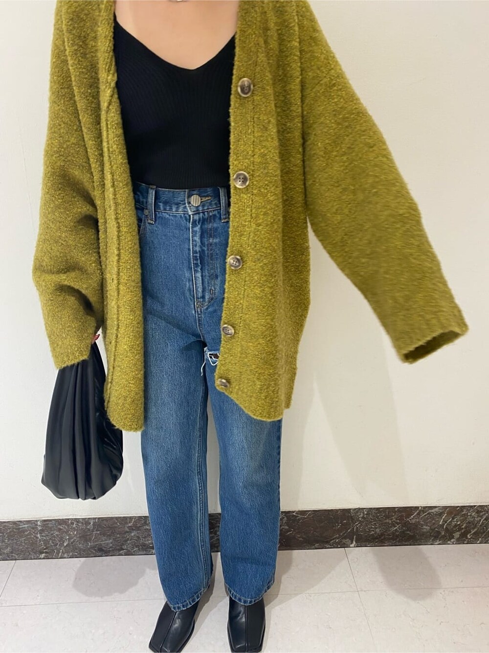 ブラック系のブーツ、ブルー系のデニムパンツ、ブルー系のデニムパンツを着用したレディースの秋コーディネートの4枚目の写真