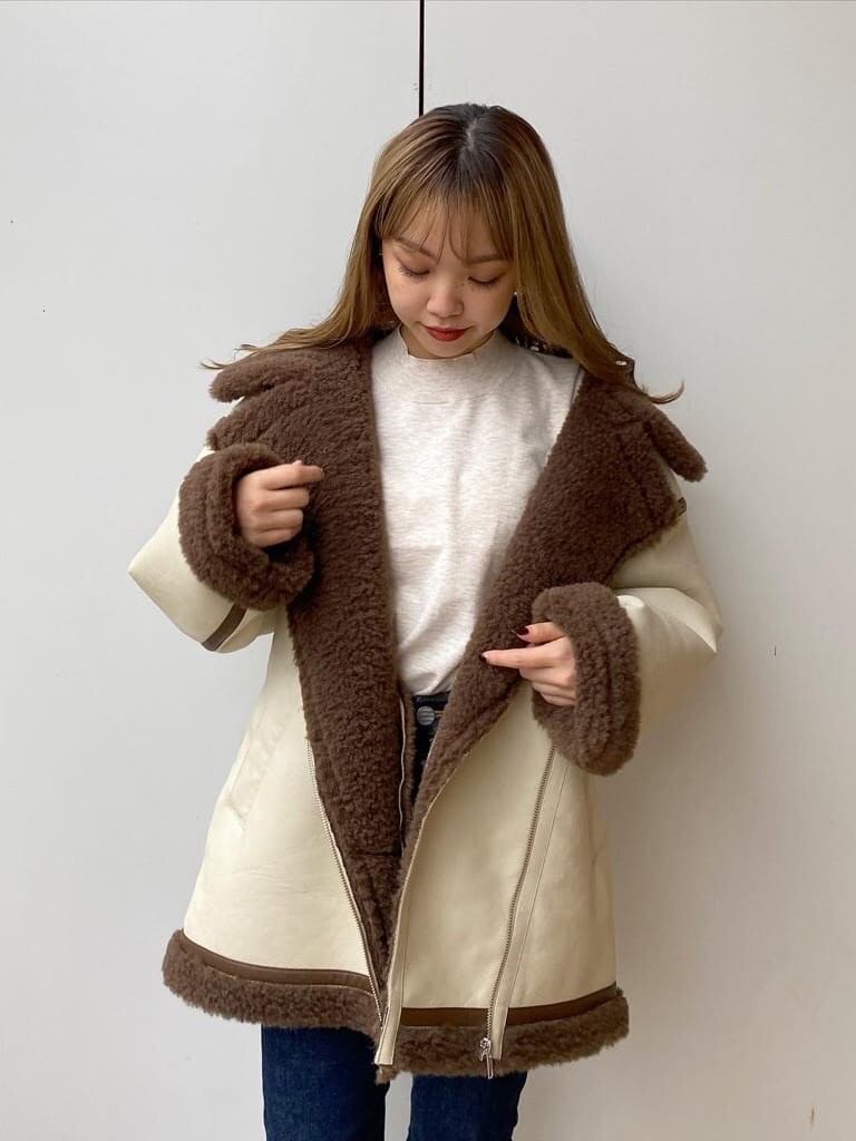 ホワイト系のブルゾン、ブラウン系のブーツを着用したレディースの秋コーディネートの3枚目の写真