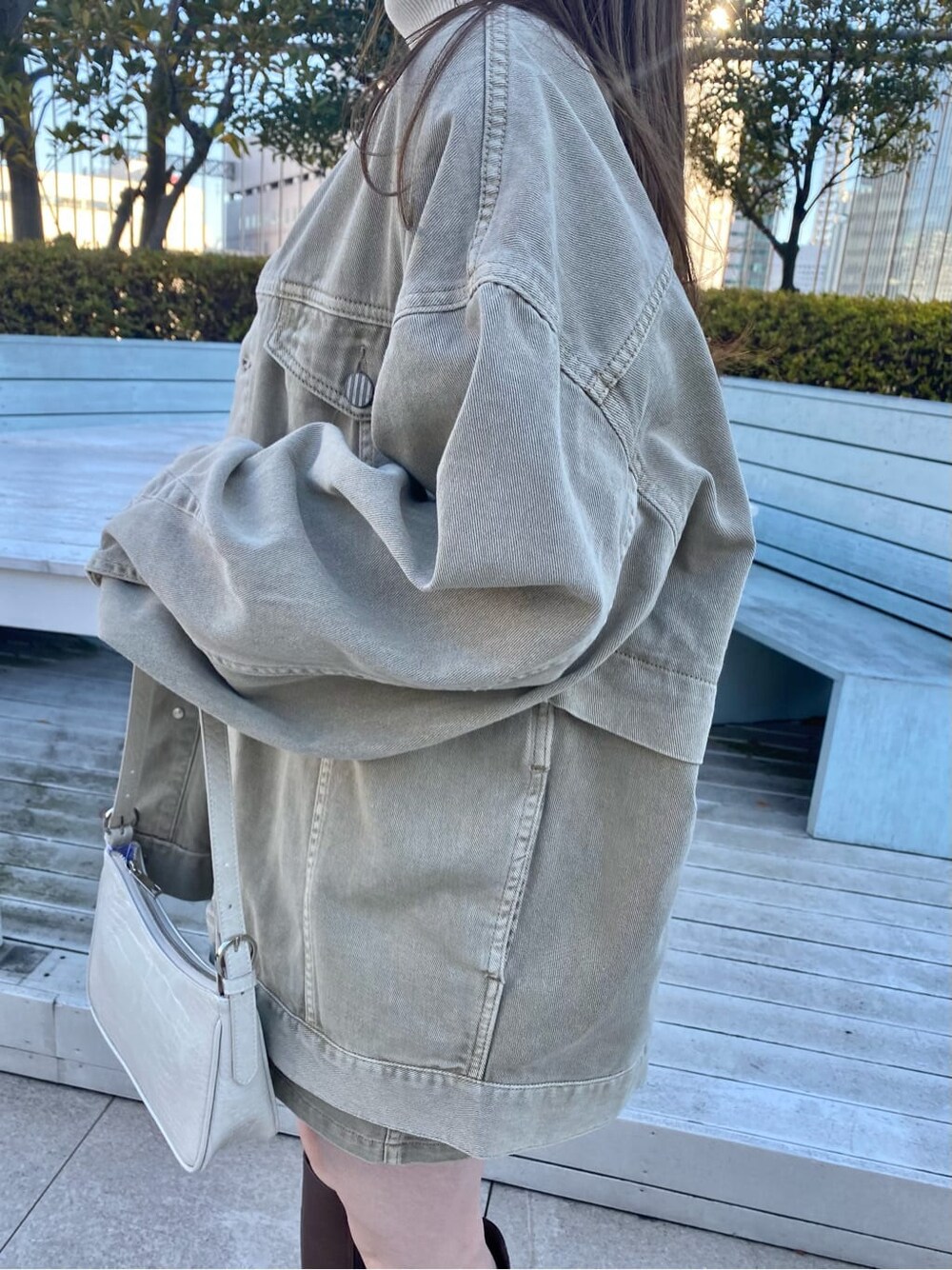 ブラウン系のブーツ、ホワイト系のニット/セーター、ベージュ系のデニムジャケットを着用したレディースの冬コーディネートの4枚目の写真