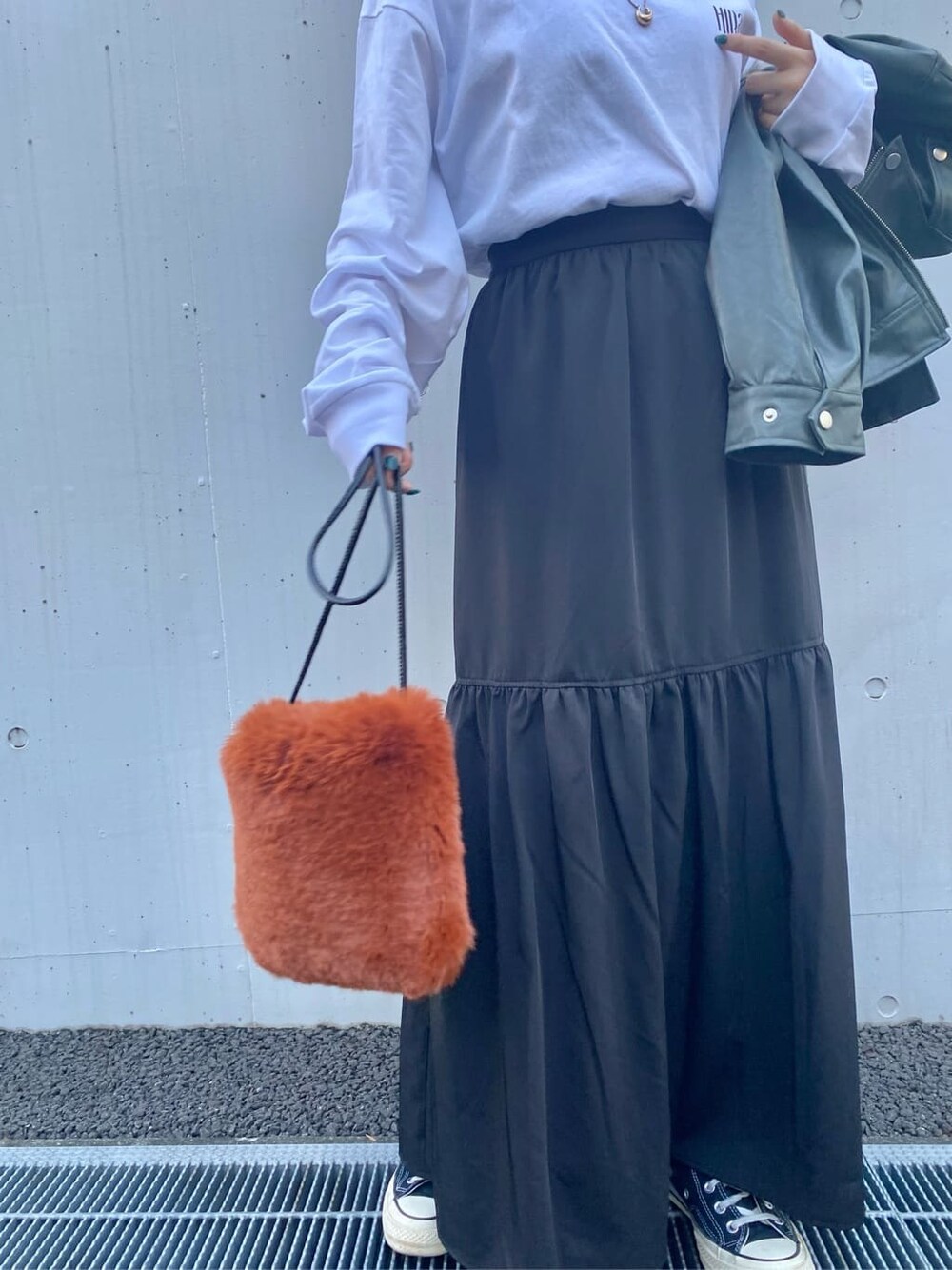 ホワイト系のTシャツ/カットソー、グリーン系のライダースジャケット、ブラック系のスカートを着用したレディースの秋コーディネートの3枚目の写真