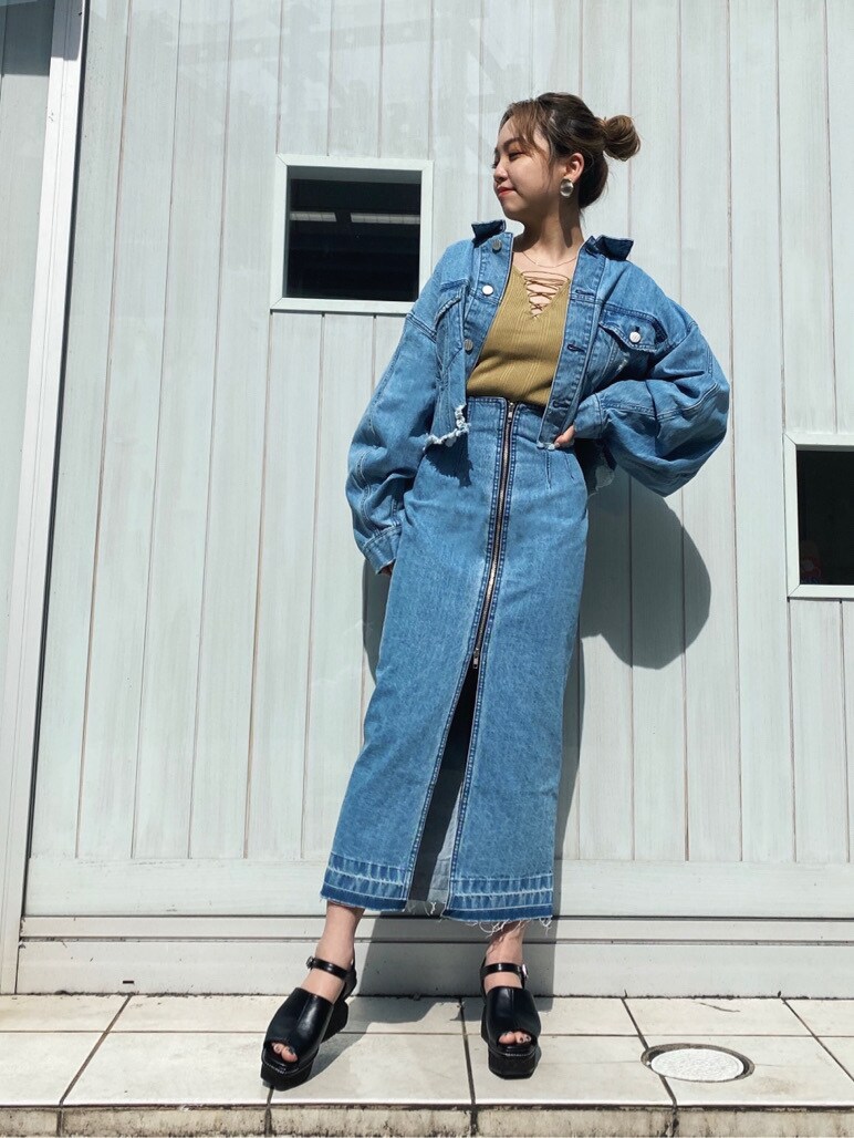 ブルー系のデニムスカート、グリーン系のニット/セーター、ブラック系のサンダルを着用したレディースの春コーディネートの4枚目の写真